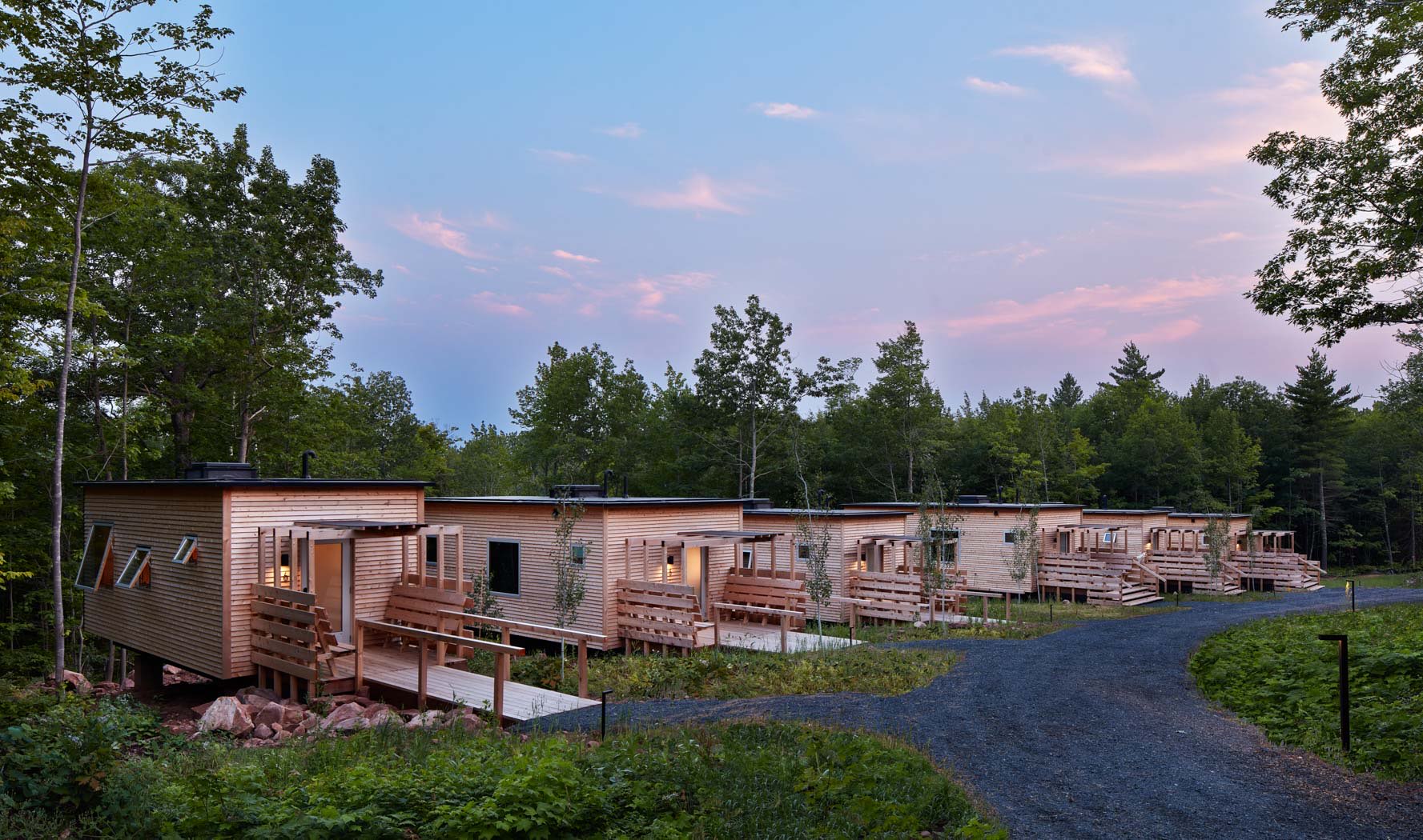 General view of some cabins surrounded by nature on a sunset