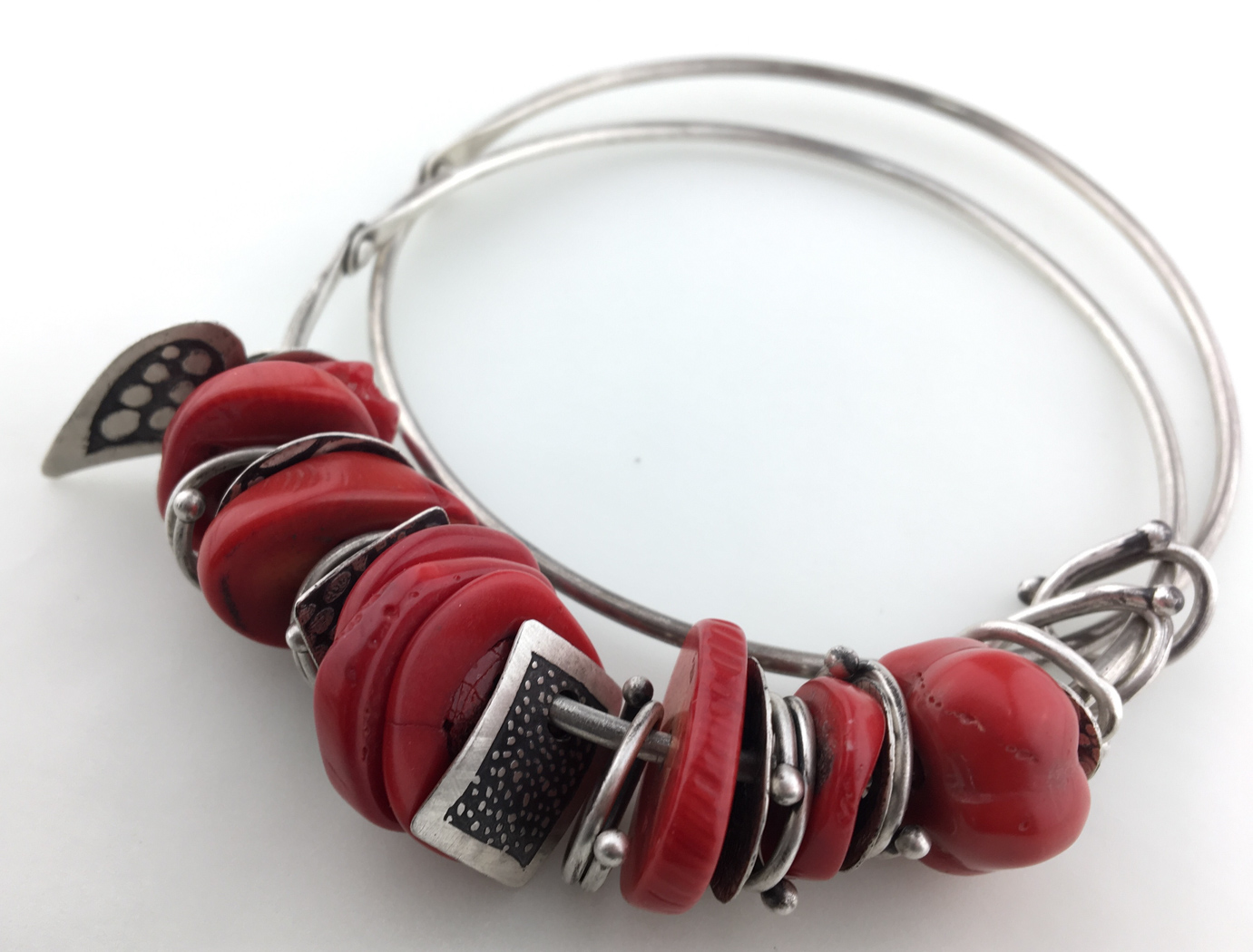 Closeup of a metal bracelet with red stones on it