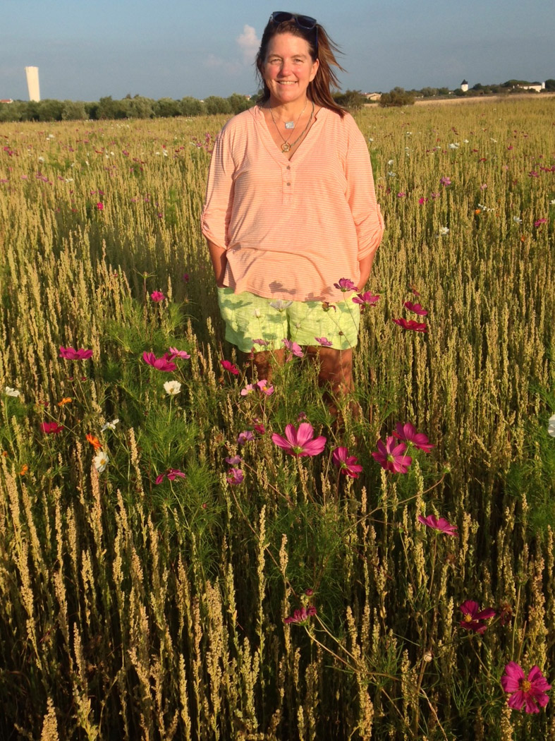 View of a happy woman standing in the middle of a flowers field