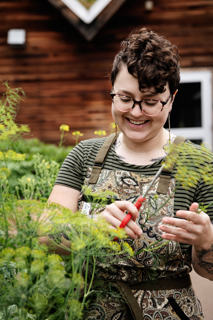 A happy woman cutting some plants outdoors 