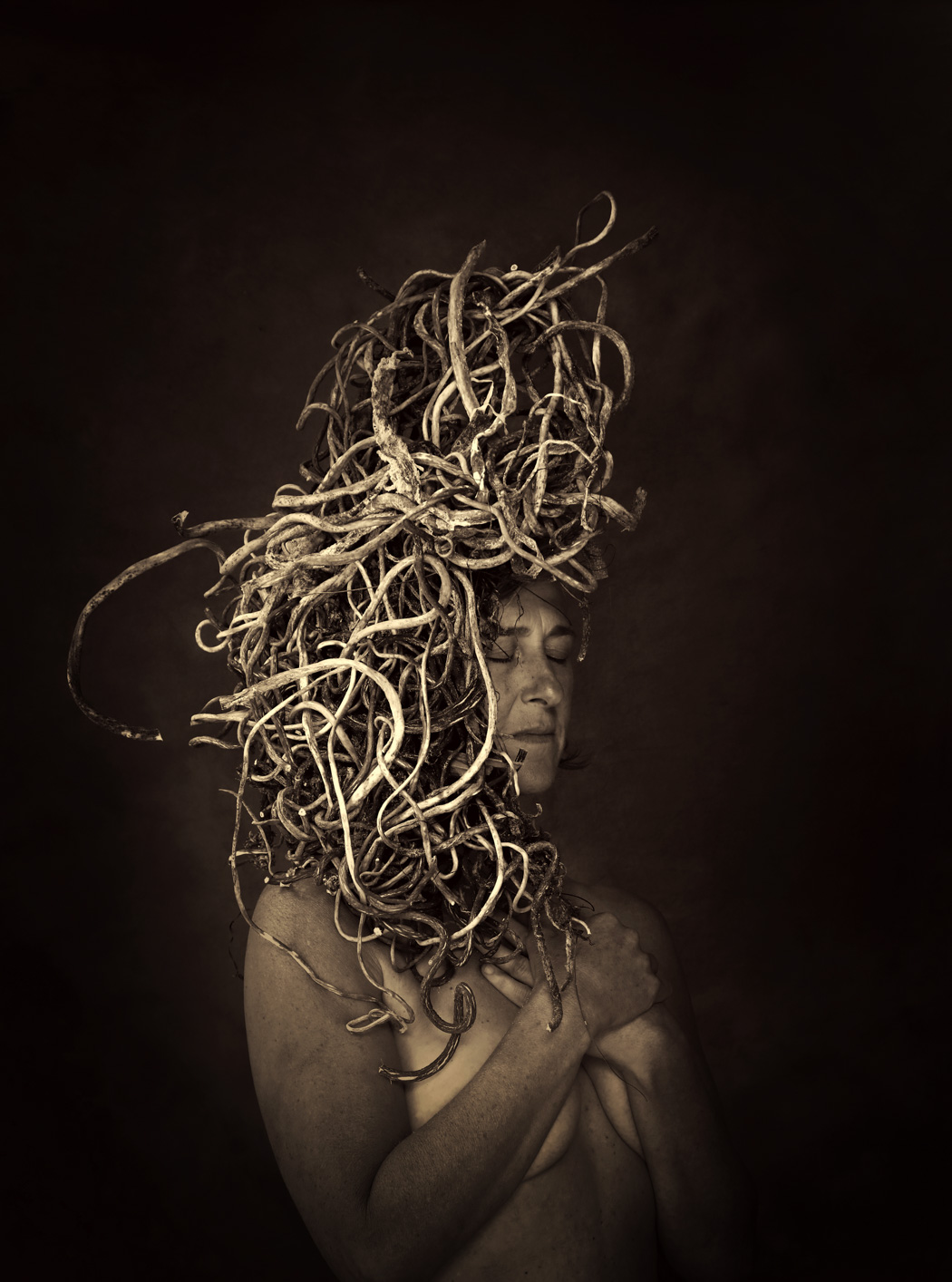 old photo of a elderly woman naked with branches in hair