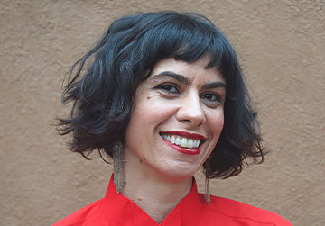 woman wearing a red shirt and lipstick smiling at the camera