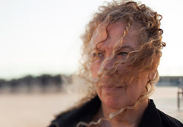woman with a curly hair looking to the left side
