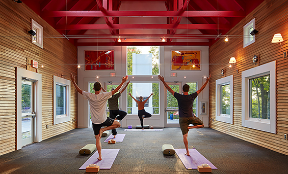 View of a group of people practicing yoga on a large room 