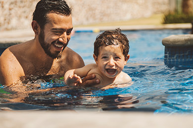 Dad playing with child in a pool