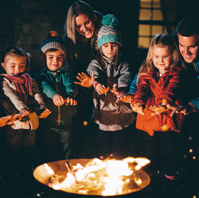 Family with children surrounded by a fire pit