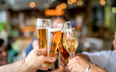 Closeup view of a group of people toasting with beer