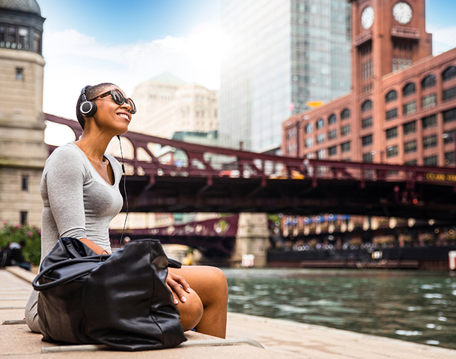 View of a beautiful lady listening to music next to a Chicago river