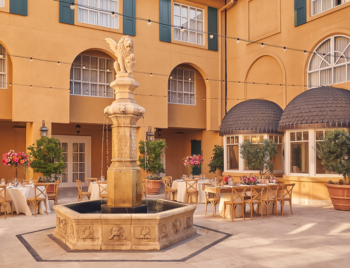 View of a beautiful fountain and some tables at the property entrance