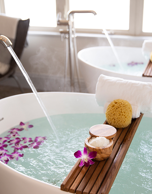 View of a bathtub with flower petals ready for a relaxing bath
