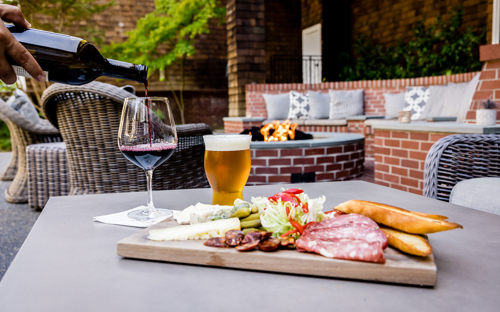 View of a charcuterie tray, a glass of wine and a cup of beer