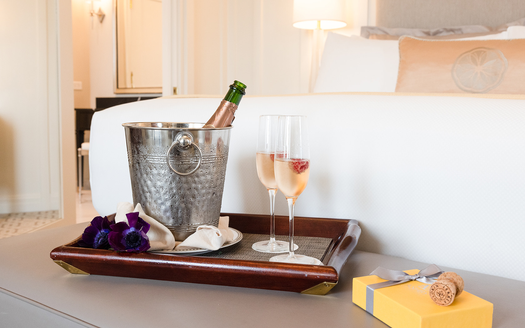 A tray with some signature treats and a bottle of champagne