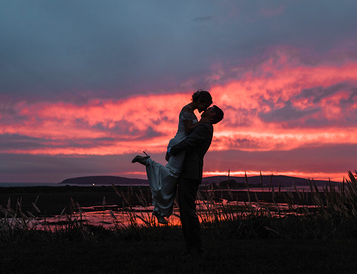 A lovely couple kissing on a romantic sunset