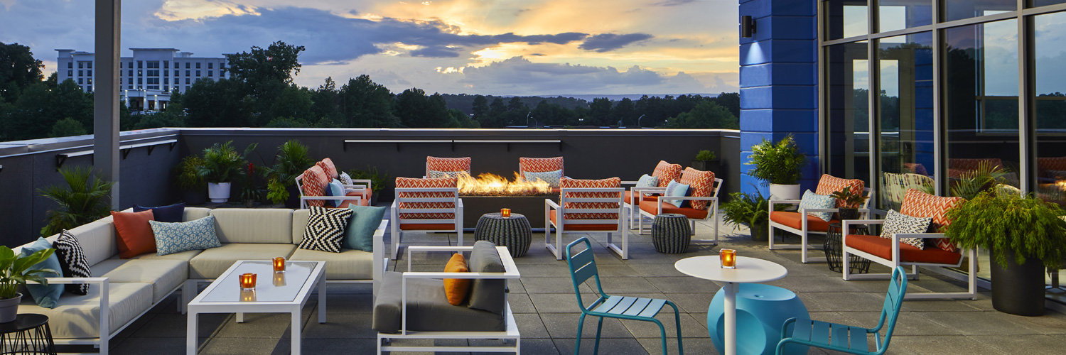 outdoor rooftop bar area with the sunset in the background
