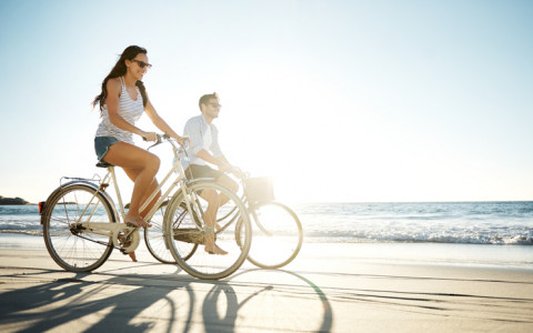 couple riding bikes on the beach