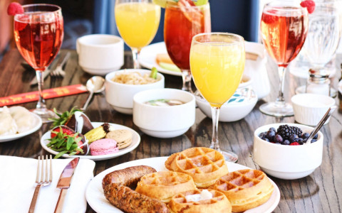 table filled with breakfast foods and cocktails