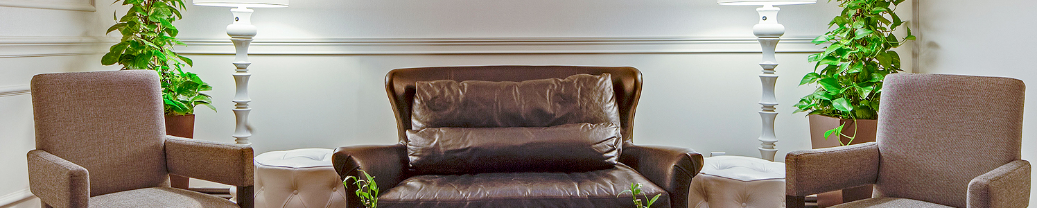 brown leather chair in the middle of two cushioned chairs