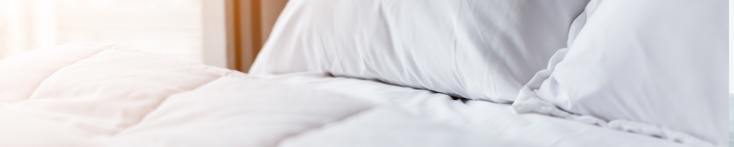 close up of a white linen bed