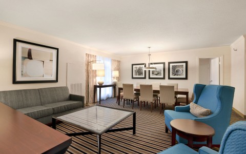 living room area within one of the larger hotel rooms that also has a dining table for 6