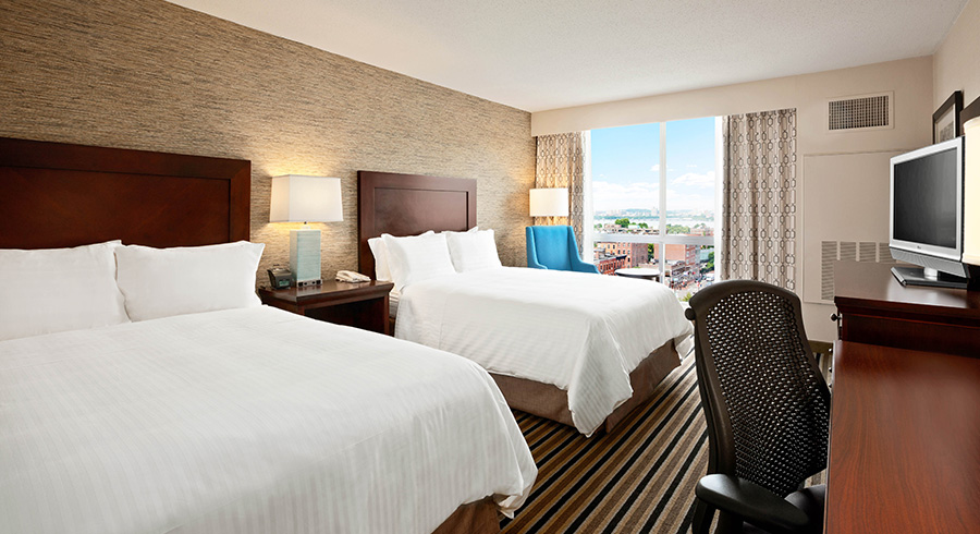 two beds within the room that has a city view