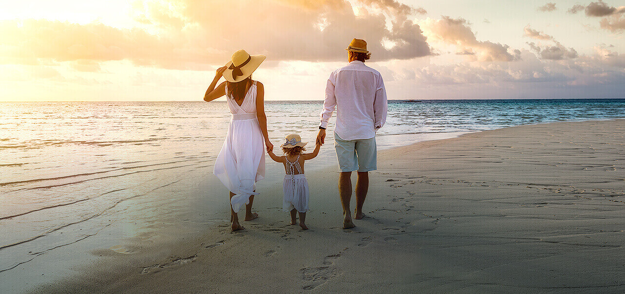 back view of a family walking on the beach 