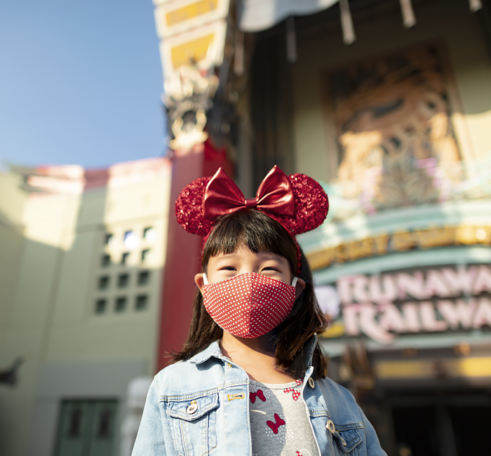 little girl posing in front of the Disney building