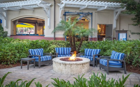 some comfy outdoor sofas around a campfire by the pool