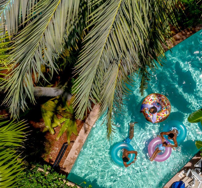 a family going down the lazy river pool in inner tubes