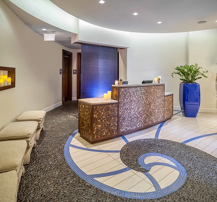 the lobby of a spa with blue tones and a swirl pattern on the floor