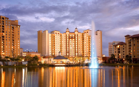 hotel view from across the water at night with lighted fountain water feature