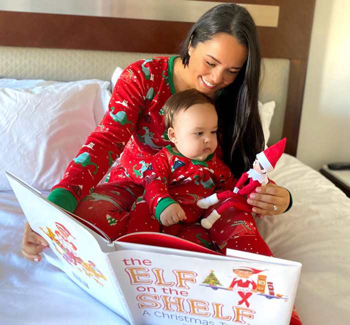 a mother and son reading a childrens book together next to elf on the shelf toy