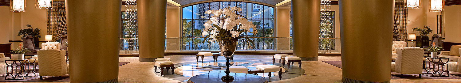 lobby sitting area with large curved window in background and table with white flowers in foreground
