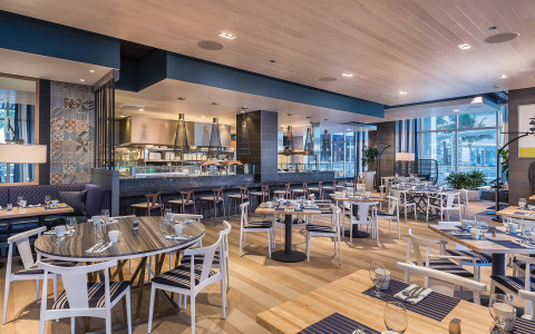 Dining area with black tables, silver chairs and fancy bar