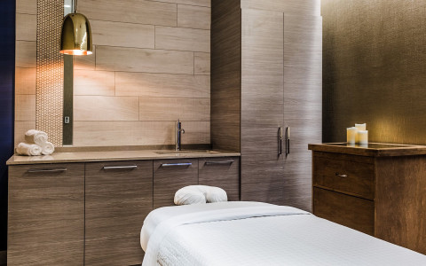 Close up of spa bed in room with warm wooden cabinets