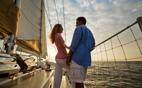 Couple standing on sailboat on the water