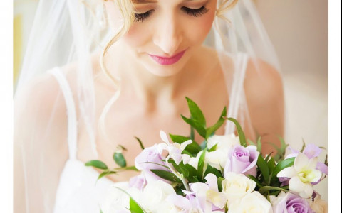 Close up of woman holding bouquet of white and lilac roses