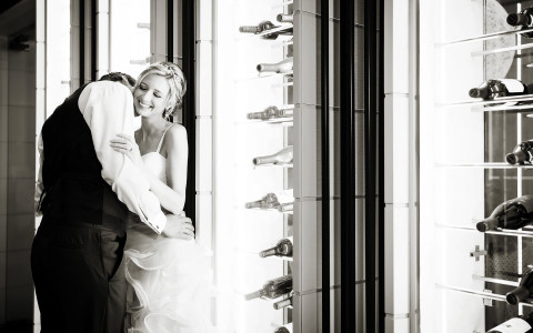 Black and white image of groom kissing bride on cheek
