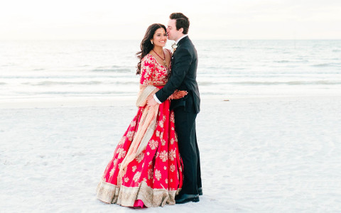 Wedding couple standing by ocean shore
