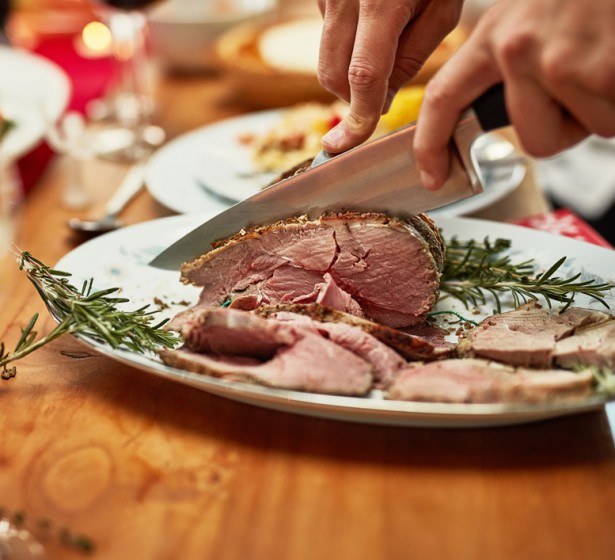 a person cutting turkey at thanksgiving brunch