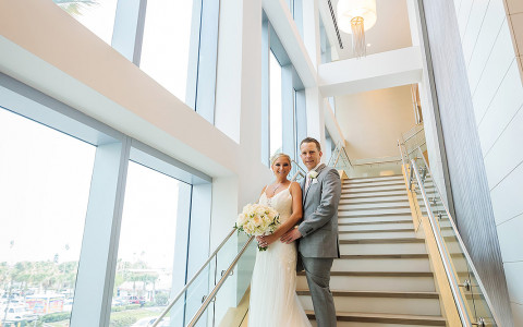 bride posing with groom on an open stairwell