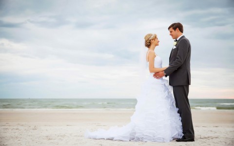 bride and groom on the beach posing for a photo