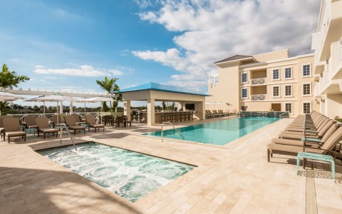 bright blue rectangular pool area with jacuzzi next to it 