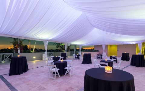 Event venue set up under a tent with purple lights