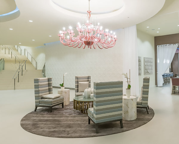 hotel lobby with chairs circling a large chandelier