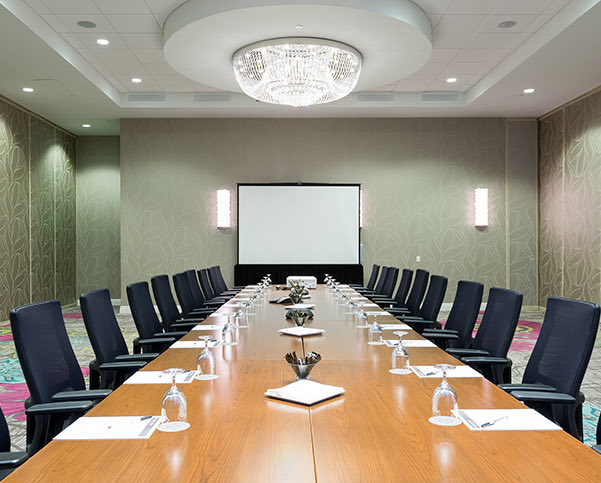 large room with wooden conference table and black leather chairs
