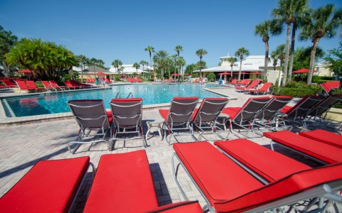 red lounge chairs lined up at a pool