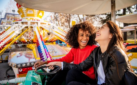 friends on bumper cars at a fair