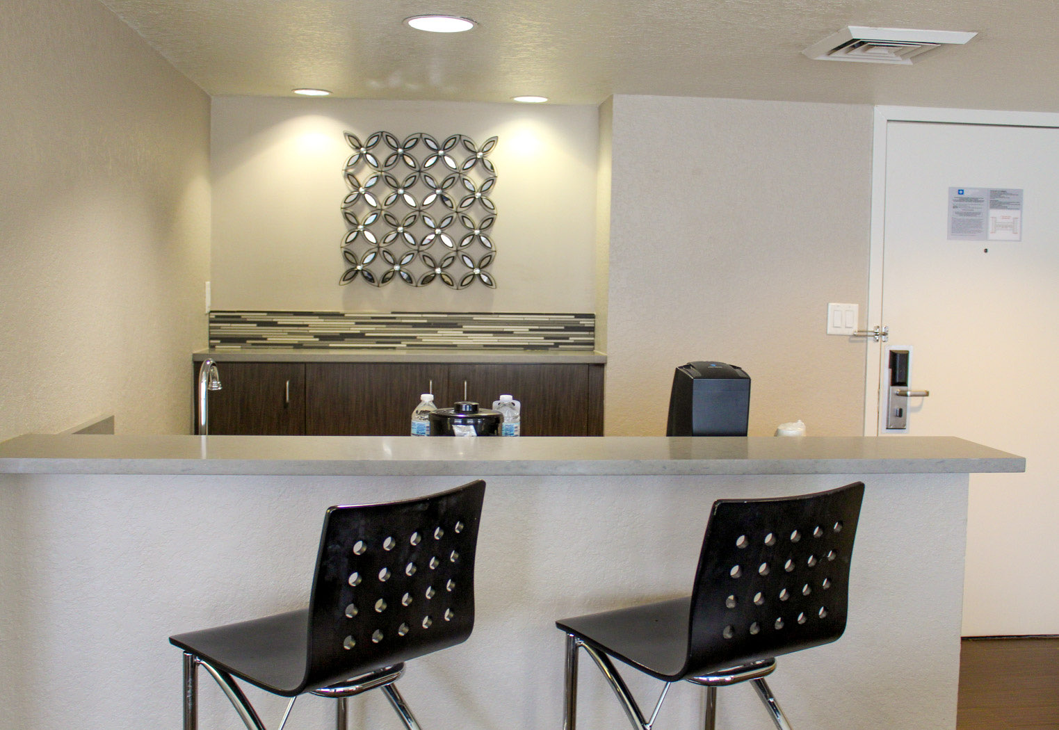 hotel suite bar area with stools and coffee station