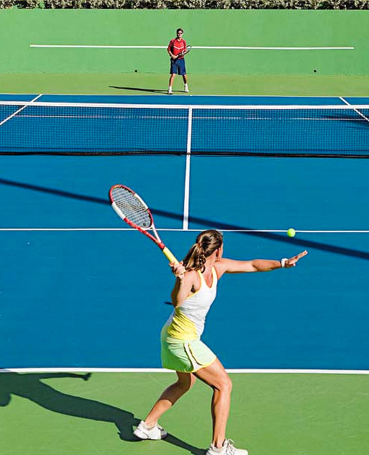 woman getting ready to hit tennis ball