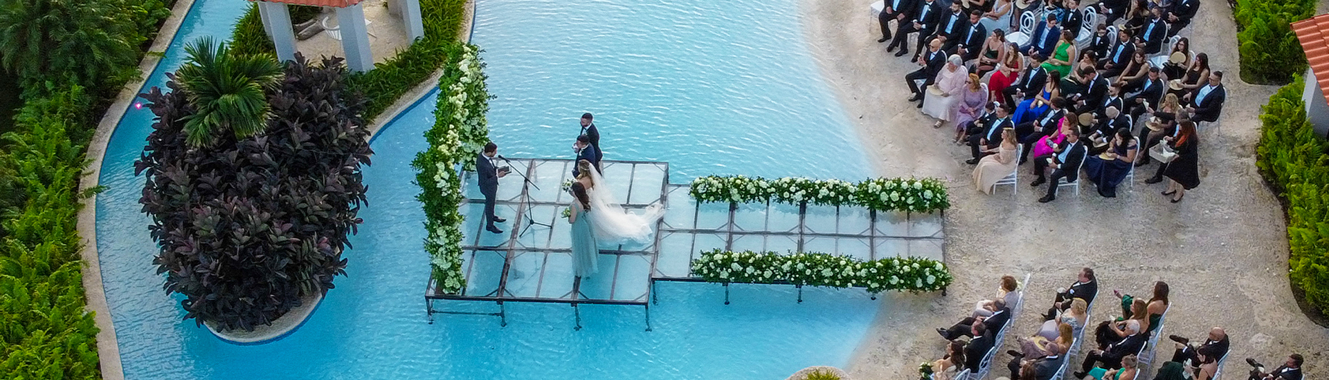 wedding happening on platform over a pool